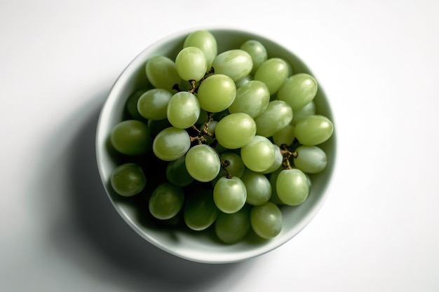 Una ciotola d'uva è su un tavolo bianco.