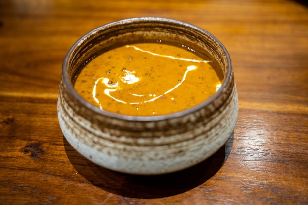 Una ciotola di delizioso dal makhani curry di lenticchie indiane con crema su un tavolo di legno