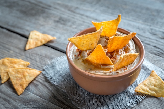 Una ciotola di hummus con patatine di mais