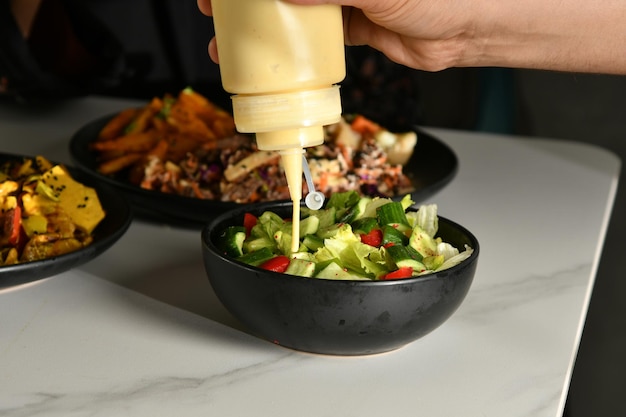 Una ciotola di insalata con una salsa di senape versata sopra.