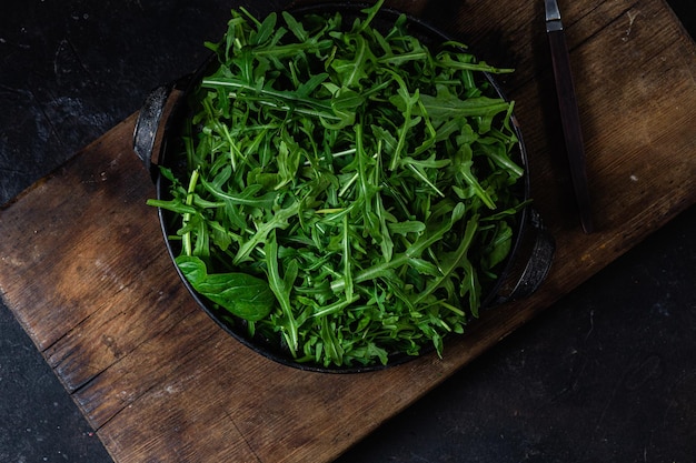 Una ciotola di insalata verde su un tagliere di legno