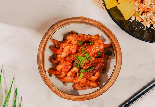 Una ciotola di kimchi con un piatto di nachos sul tavolo