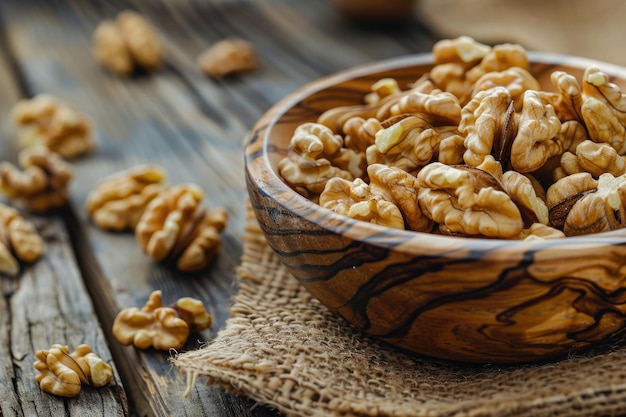 Una ciotola di legno piena di ricche noci di pecan intere si trova su una superficie strutturata che offre un'opzione di spuntino sano e gustoso