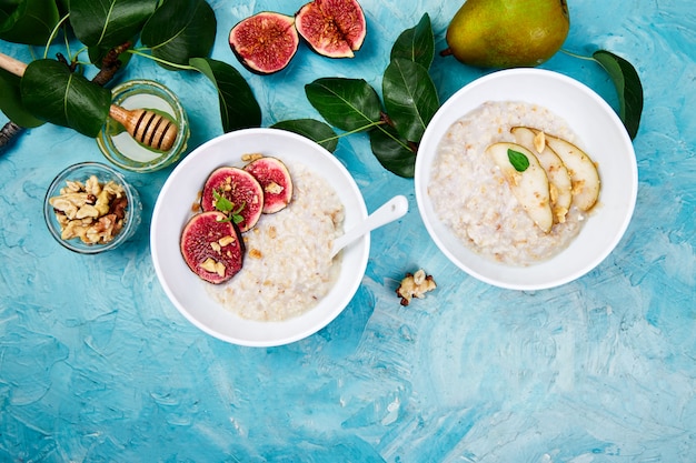 Una ciotola di porridge con fette di pere e noci e porridge con fichi