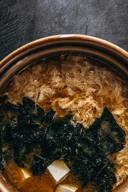 Una ciotola di riso con verdure verdi e uno sfondo nero