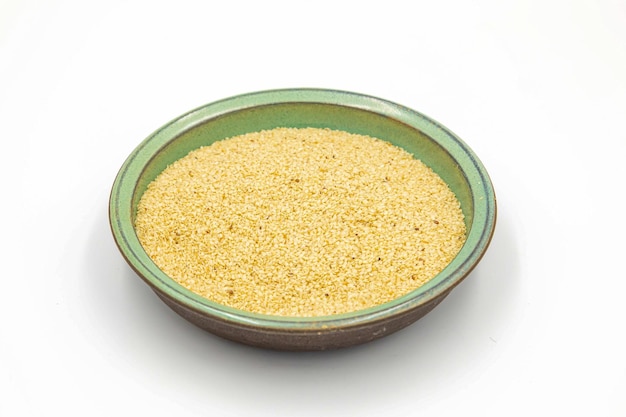 Una ciotola di riso giallo è su uno sfondo bianco.