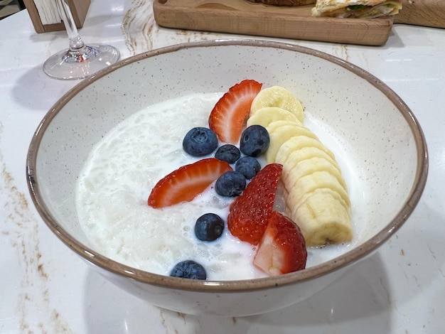 Una ciotola di yogurt con fragole e banane.