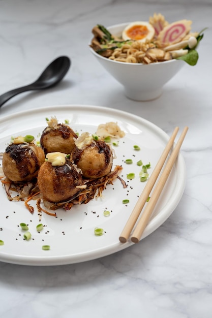 Una ciotola di zuppa Ramen e un piatto di snack Takoyaki