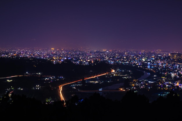 Una città di notte con un cielo viola e luci