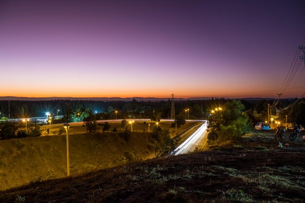 Una città di notte con un cielo viola e un lampione.