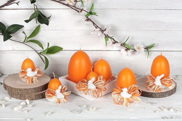 Una collezione di candele con candele arancioni su di esse con uno sfondo bianco.