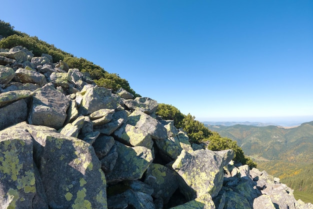 Una collina rocciosa con grandi massi di pietra in una giornata di sole.