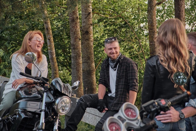 Una compagnia di amici viaggia insieme in motocicletta ferma sul ciglio della strada, si diverte e beve il tè