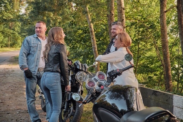 Una compagnia di amici viaggia insieme in motocicletta ferma sul ciglio della strada, si diverte e beve il tè