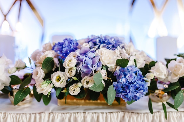 Una composizione di fiori e verde è su un tavolo festivo nella sala banchetti Decorazioni per matrimoni Primo piano