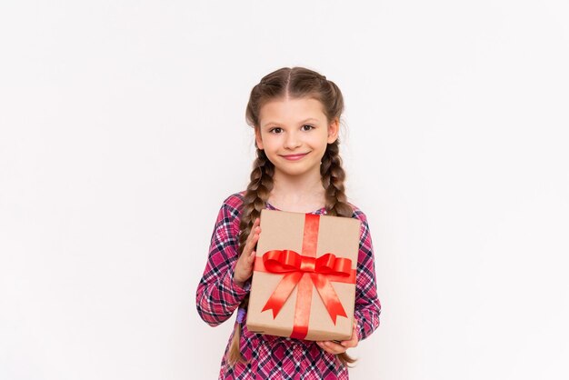 Una confezione regalo nelle mani di una bambina felice Un regalo di compleanno Sfondo bianco isolato