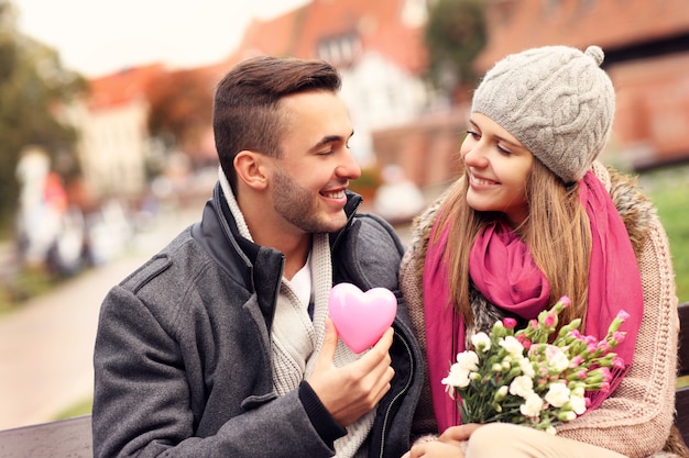 una coppia a San Valentino nel parco con fiori e cuore