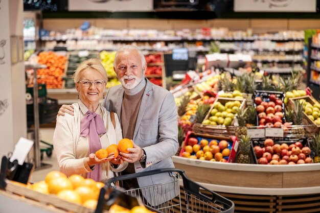 Una coppia anziana sana sta acquistando frutta al supermercato