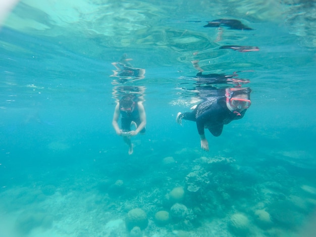 Una coppia che nuota sott'acqua con vista sul corallo sotto il mare di karimun jawa