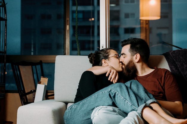 Una coppia di amanti che si baciano sul divano con amore con lo spazio della copia