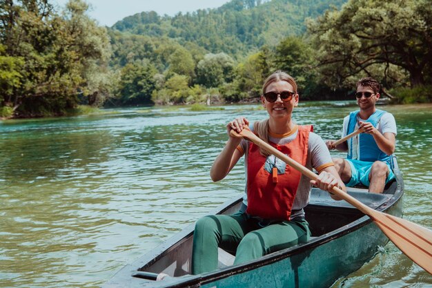 Una coppia di amici esploratori avventurosi va in canoa in un fiume selvaggio circondato dalla bellezza della natura.