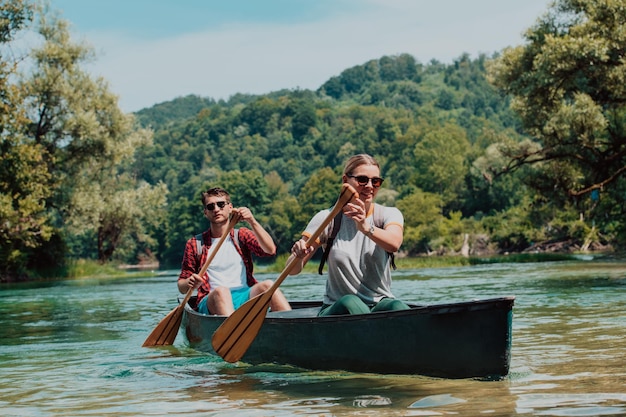 Una coppia di amici esploratori avventurosi va in canoa in un fiume selvaggio circondato dalla bellezza della natura.