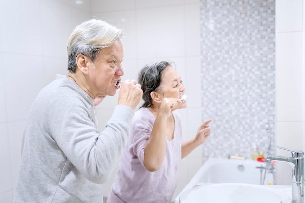 Una coppia di anziani che si lavano i denti in bagno.