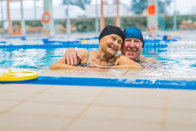 Una coppia di anziani che si rilassano in piscina e si abbracciano l'un l'altro concetto di amore per anziani