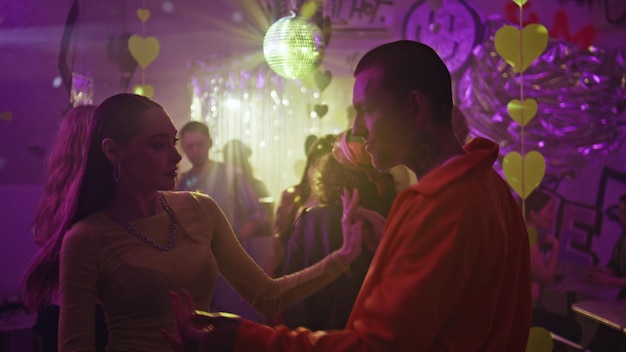 Una coppia di ballerini si diverte a fare movimenti energetici sulla pista da ballo di un discoteca