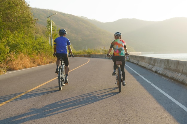 Una coppia di ciclisti asiatici che si esercitano insieme intorno al lago al mattino