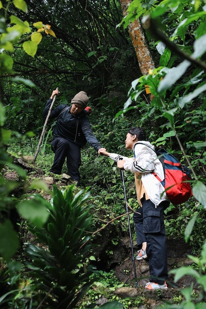 Una coppia di giovani escursionisti con zaini a piedi attraverso la foresta