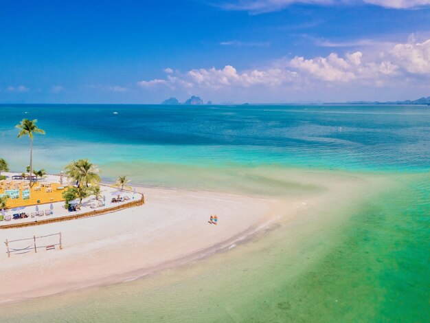 una coppia di uomini e donne che camminano sulla spiaggia durante una vacanza tropicale in Thailandia