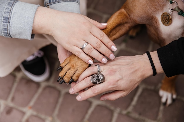 Una coppia e i loro cani si tengono per mano con un teschio sulle dita.