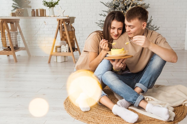 una coppia è seduta sul pavimento e mangia una torta bento con la scritta amore è e abbracci