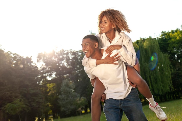 Una coppia felice afroamericana cammina insieme nel parco in estate e guarda lo spazio di copia