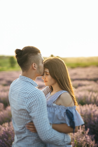 Una coppia felice che bacia al tramonto nel giacimento della lavanda.