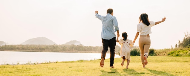 Una coppia felice che corre mano nella mano in una soleggiata giornata estiva con uno sfondo di natura bellissima in un viaggio romantico insieme cura della famiglia