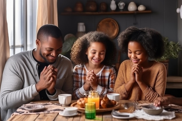 Una coppia felice di famiglie multirazziali con figli prega insieme prima di fare la colazione mattutina a casa insieme genitori multietnici con bambini di razza mista si tengono per mano dicono la preghiera siedersi al tavolo della cucina