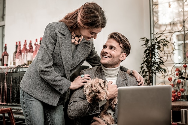 Una coppia felice. Donna che abbraccia il suo ragazzo che tiene un cane