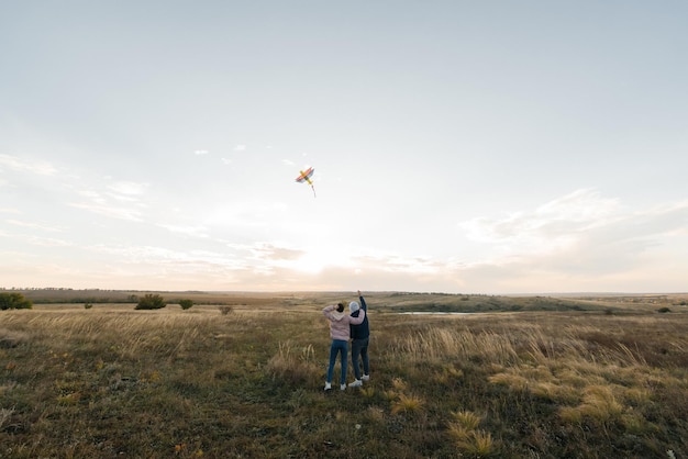 Una coppia felice fa volare un aquilone e trascorre del tempo insieme all'aperto in una riserva naturale Relazioni felici e vacanze in famiglia Libertà e spazio