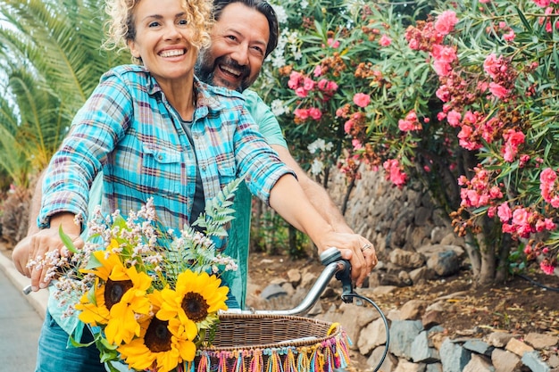 Una coppia felice sorride e va in bicicletta insieme in uno stile di vita attivo per il tempo libero all'aperto Trasporto sano e verde Trasporto sostenibile L'uomo e la donna si godono il tempo libero al parco Amore