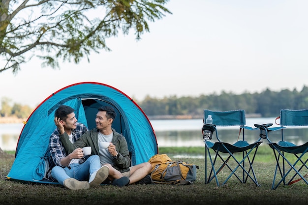Una coppia gay asiatica felice in campeggio insieme in una foresta viaggio di vocazione romantica concetto lgbt
