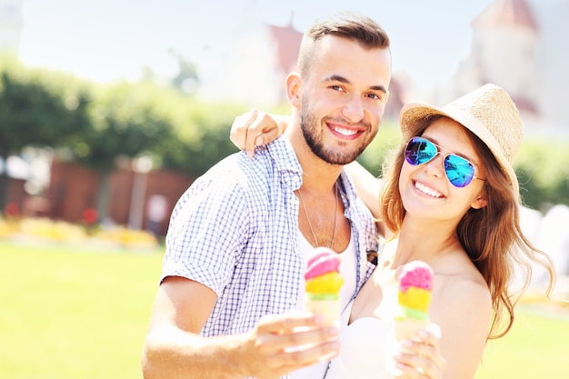 una coppia gioiosa che mangia coni gelato nel parco