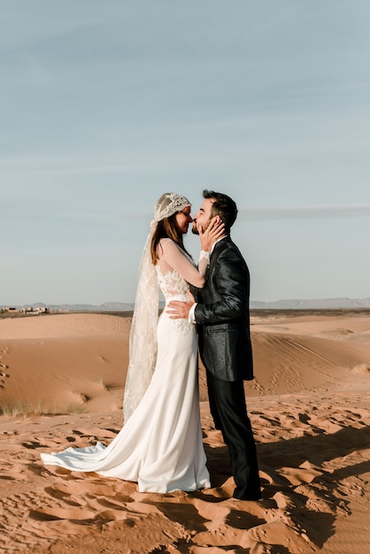 Una coppia in abiti da sposa nel deserto