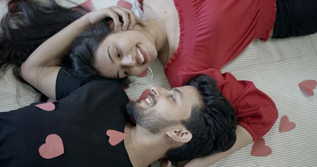 Una coppia indiana sdraiata su un letto e che si tocca felicemente - concetto della prima notte