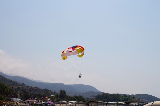 Una coppia innamorata vola nel cielo su un paracadute dietro uno yacht. Una famiglia che ama il divertimento rischioso. Vacanze al mare nei paesi del sud