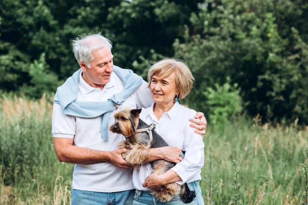 Una coppia matura sta camminando con un cane in un parco