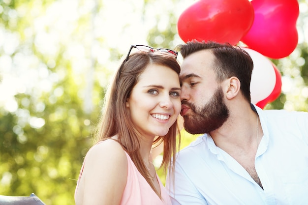 Una coppia romantica in piedi fuori con palloncini