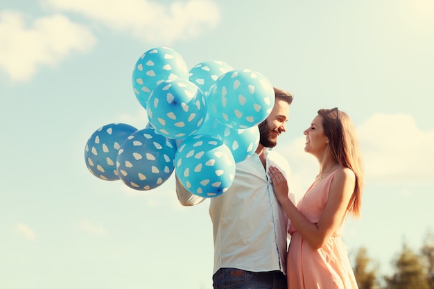 Una coppia romantica in piedi fuori con palloncini