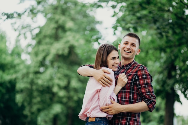 Una coppia sorridente che si abbraccia nel parco
